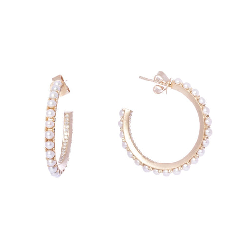 These hoop earrings feature baby freshwater pearls with the prong set on the outer perimeter and a single row of diamond pave on the inner quarter.  14k yellow gold 30 mm post Total diamond carat weight: 0.17 ct. Made in USA