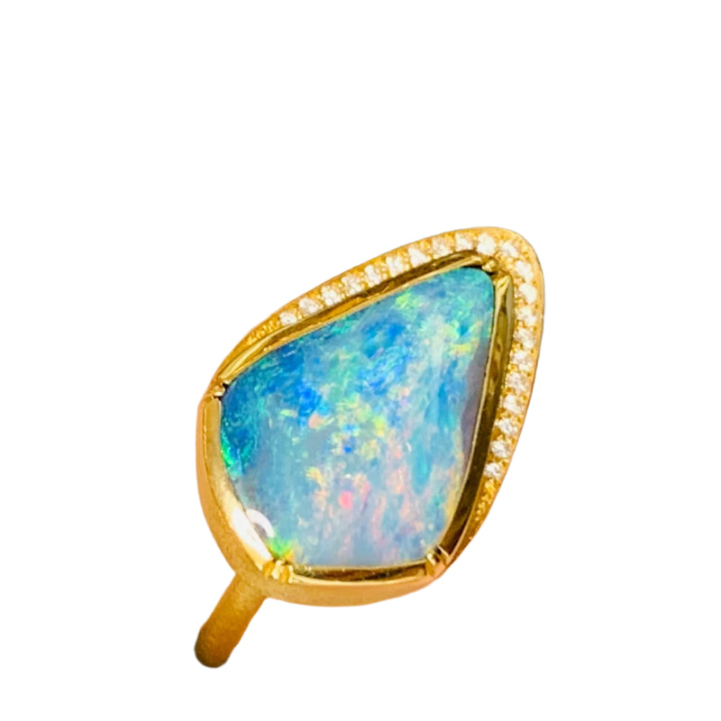 Nestled at the heart of this exquisite creation is a boulder opal of unparalleled beauty. Its captivating play-of-color dances across the surface, revealing an intricate spectrum of iridescence reminiscent of a hidden oasis within the opal's depths. The opal's rich hues, ranging from deep ocean blues to fiery oranges and lush greens, create an ever-shifting kaleidoscope of enchantment that holds the gaze and ignites the imagination. 18K YG   Opal 6.38ct, Diamond pave .21c